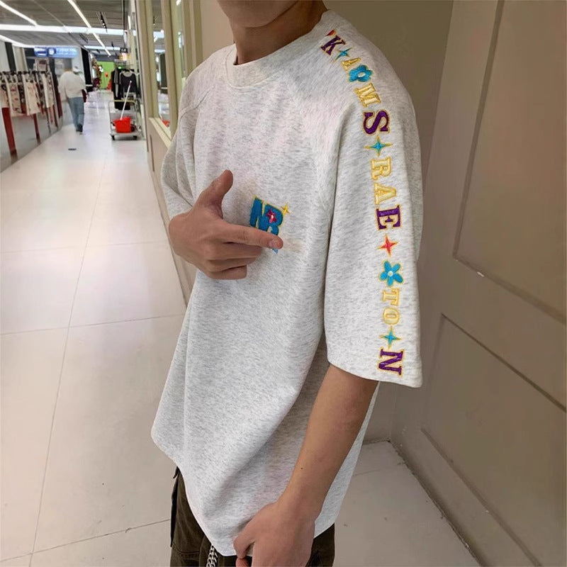 Person wearing a white t-shirt with colorful text design in a store setting